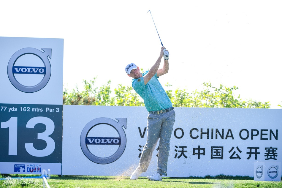 第13洞三杆洞的赛场全景，蓝色水障碍环绕着精致的果岭，沃尔沃中国公开赛的标志在发球台旁格外醒目。