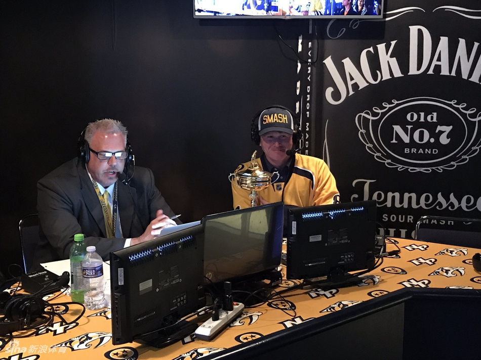 斯内德克尔俯下身，亲切地与一位年轻的小冰球迷击掌，脸上洋溢着温暖的笑容。