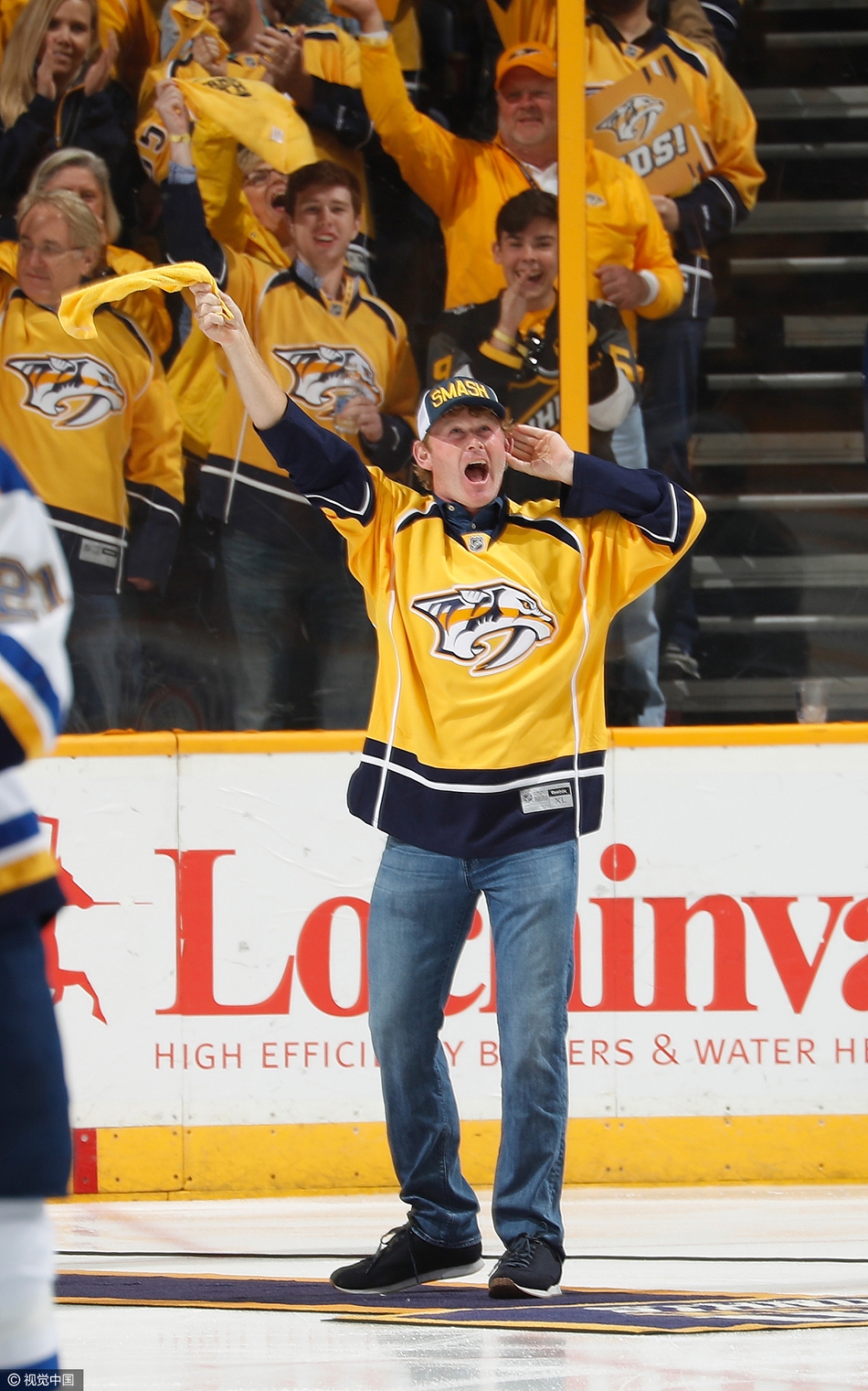 斯内德克尔面带标志性微笑，在聚光灯下向全场冰球迷展示闪亮的莱德杯奖杯。