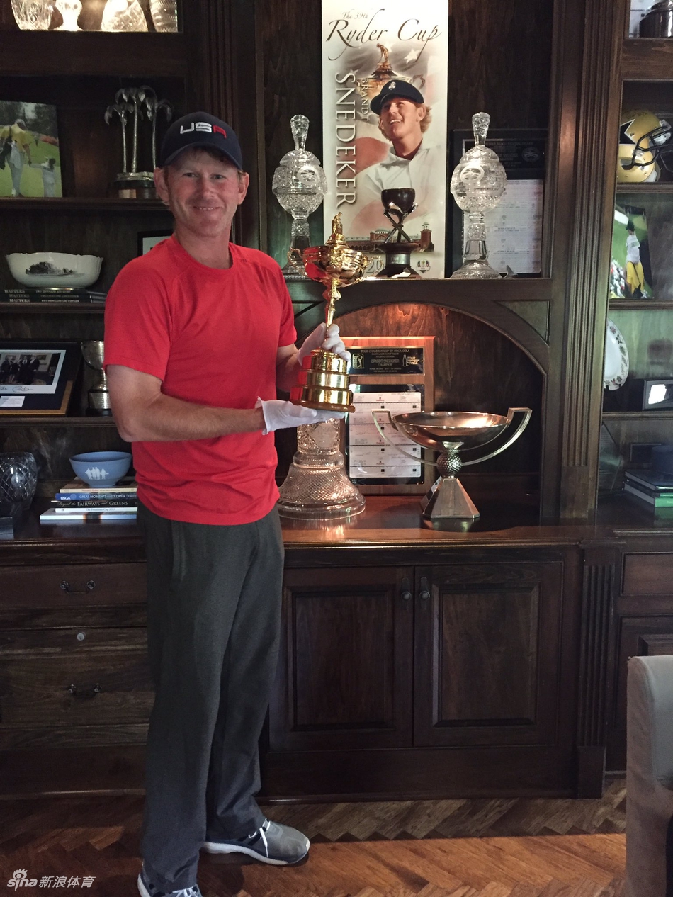 特写镜头下，斯内德克尔眼神坚定，双手稳稳托举着莱德杯，杯身映照出场馆的璀璨灯光。