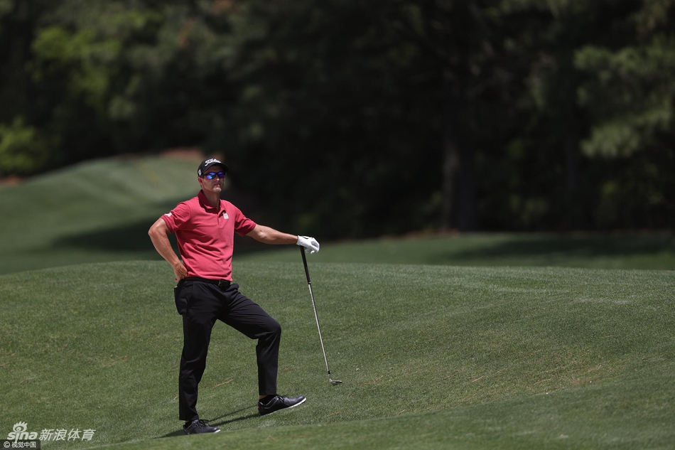 亚当·斯科特凝神观察果岭，为关键一推做最后准备，场面静谧而紧张