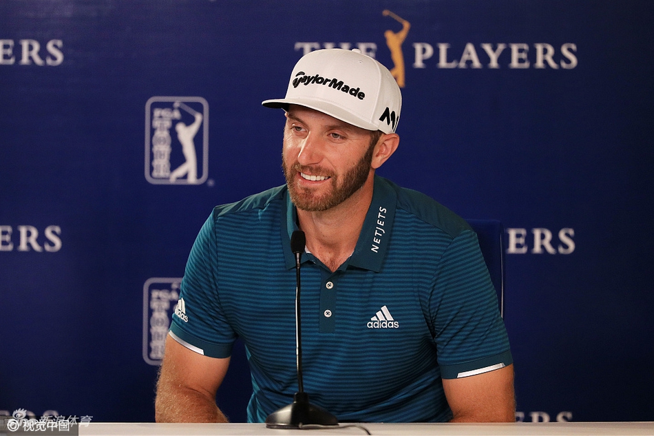 乔丹·斯皮思弯腰耐心地为一位小球迷在高尔夫球上签名,神情温和友善。