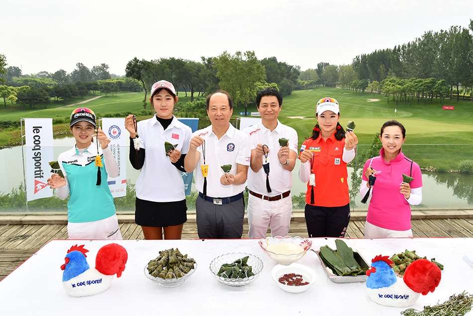 张维维与刘文博合作包粽子，刘文博手持未完成的粽子向张维维请教，画面生动有趣