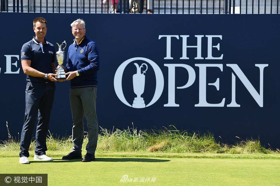 斯滕森与赛事官员一同展示葡萄酒壶,象征着冠军荣誉从上一届得主向赛事的正式移交