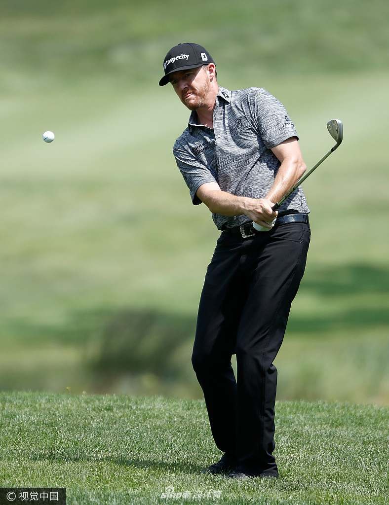 杰米·沃克尔在果岭边专注切杆，表情认真，评估着球落地的每一寸滚动。