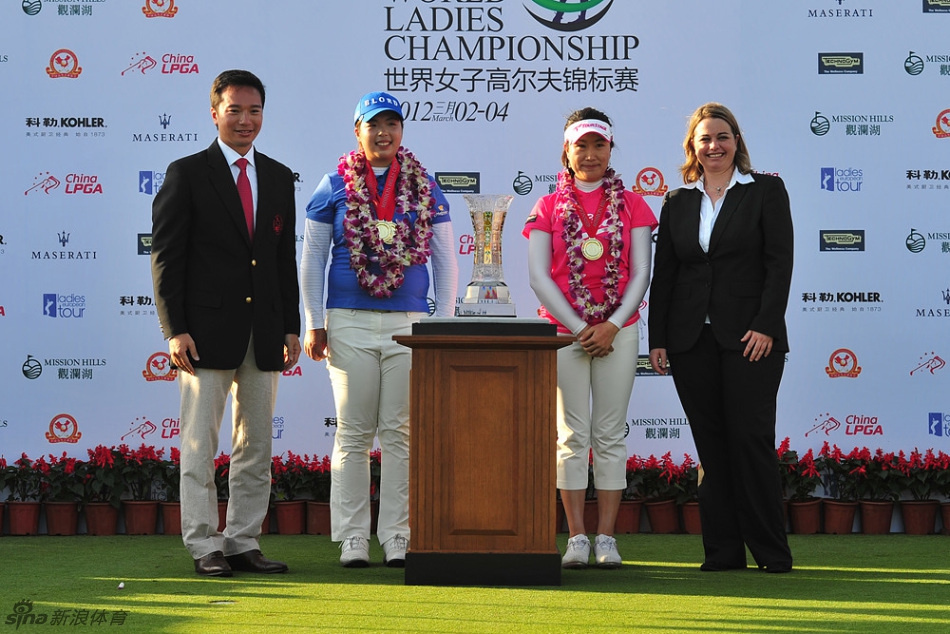 冯珊珊与搭档叶莉英在队际赛颁奖礼上高举奖杯，两人笑容灿烂，庆祝来之不易的团队胜利