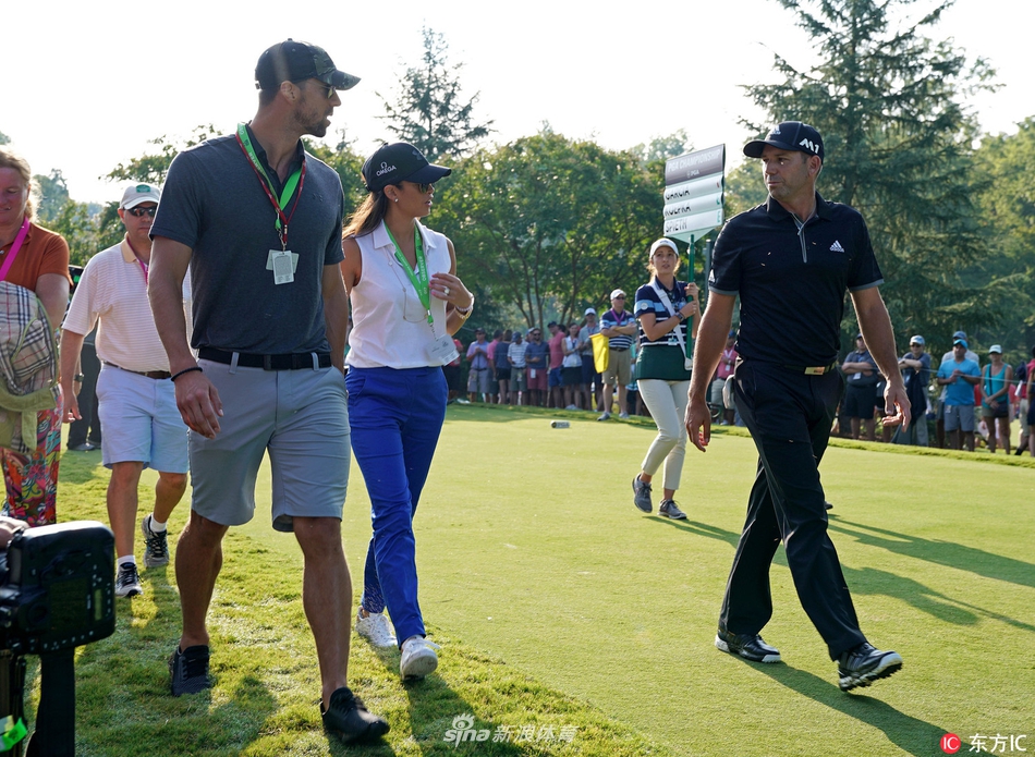 菲尔普斯与塞尔吉奥·加西亚面对面站立，笑容灿烂地进行交谈。加西亚手持高尔夫球杆，菲尔普斯则神态放松，两人仿佛老友重逢，背景是典型的球场会所建筑。