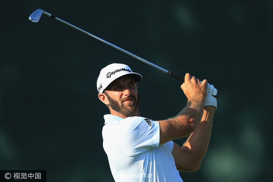 达斯汀·约翰逊在球道上大力挥杆，白色高尔夫球在蓝天背景下划出一道优美弧线