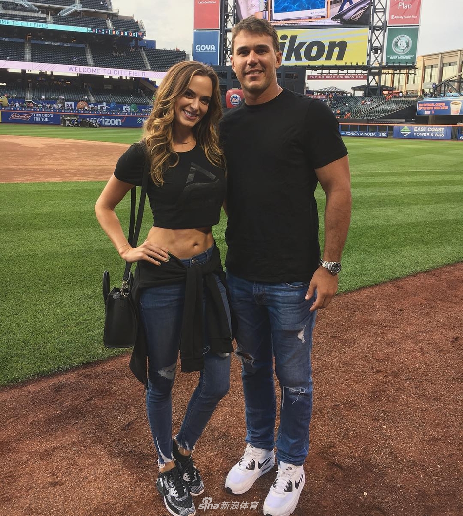 杰娜倚靠于白色阶梯，身着设计感十足的镂空连体泳衣，姿态放松，眼神中流露自信与从容。