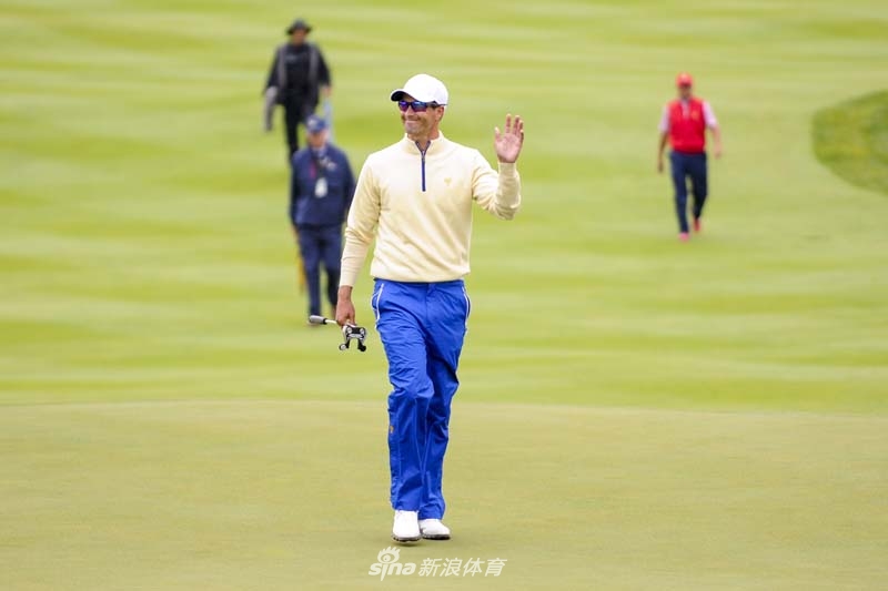 亚当·斯科特在果岭边进行切杆，他的动作一如既往的优雅从容，小白球划过一道精准的弧线飞向旗杆。