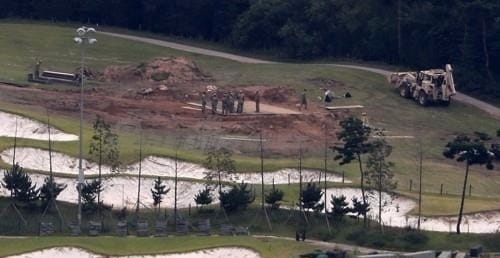 大型军用运输车辆驶入基地内部，扬起尘土，标志着这片土地的功能和命运已被永久性改写。