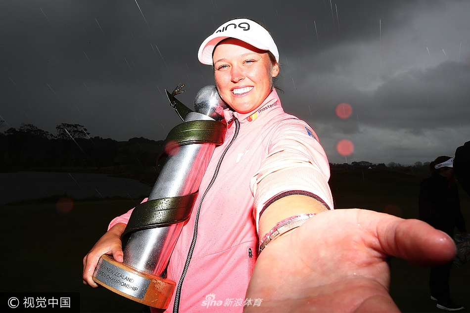 冠军风采：亨德森手捧奖杯与毛利羽毛斗篷，面露灿烂笑容