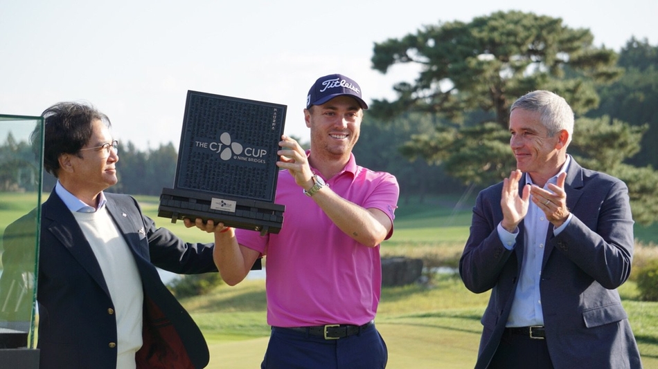 贾斯汀·托马斯深情捧起希杰杯冠军奖杯，脸上洋溢着梦想成真的喜悦与自豪。