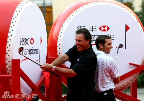 米克尔森面带标志性笑容，手指棋盘，似乎正在向对面的伍兹解释一步棋的走法，气氛轻松又紧张。