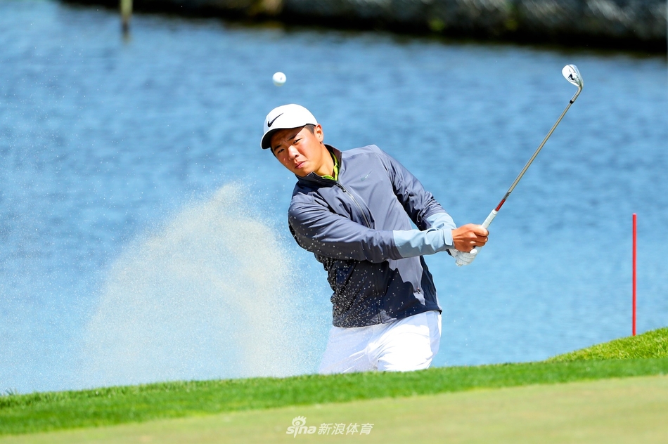 张华创在练习果岭上推杆,神情认真评估草皮状态