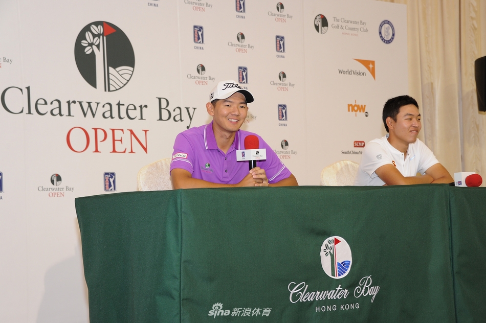 开幕照拍摄花絮，金诚与黑纯一在摄影师的引导下调整姿态，背景中的赛事旗帜随风飘扬，捕捉到两人在正式拍摄间隙自然流露的专注神情。