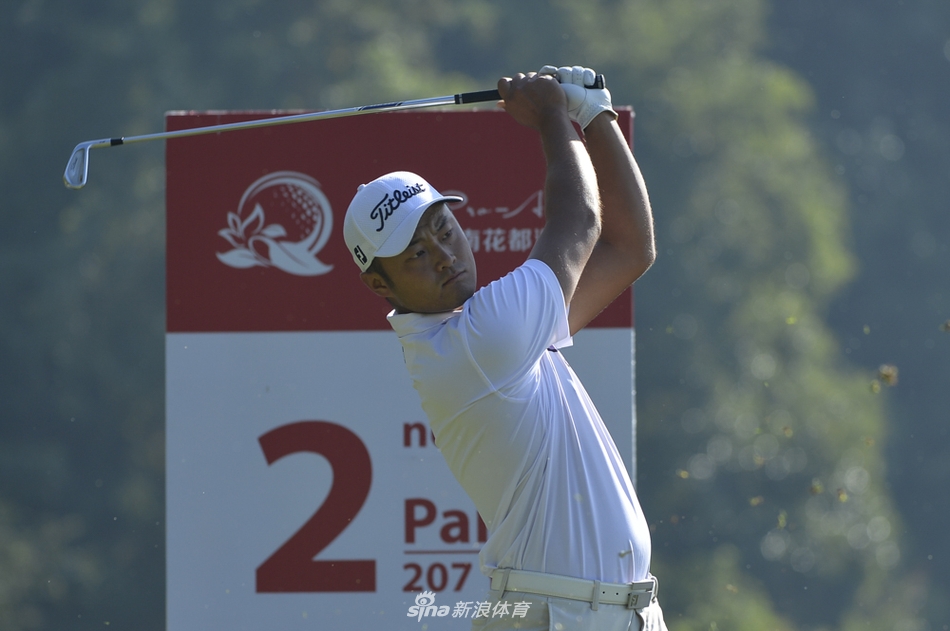 比赛间歇，球员何绍才在练习果岭上进行推杆热身，表情轻松而自信。