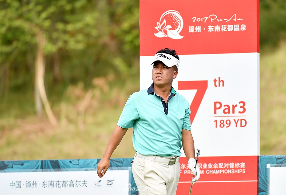 选手张进全神贯注地完成一记精准的铁杆击球，背景是开阔的赛场与蔚蓝天空。