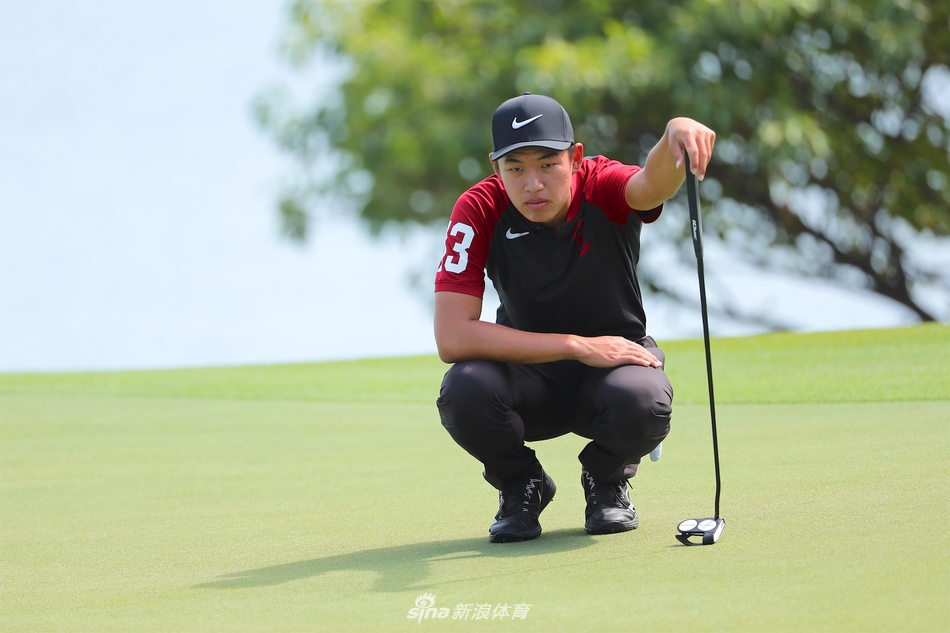 金诚在清水湾球场果岭边凝神观察推击线路，表情专注，仿佛在阅读这片赋予他荣耀的草地密码