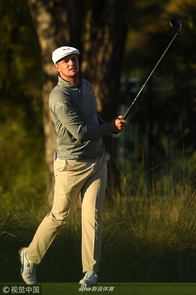 布莱森-德尚博使用测距仪观察远处落点，表情严肃，展现其科学化打球的一面。