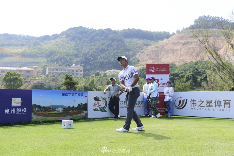 张进在果岭边屈膝观察推杆线路，神情严峻，仿佛在破解一道关乎胜负的绿色几何难题。