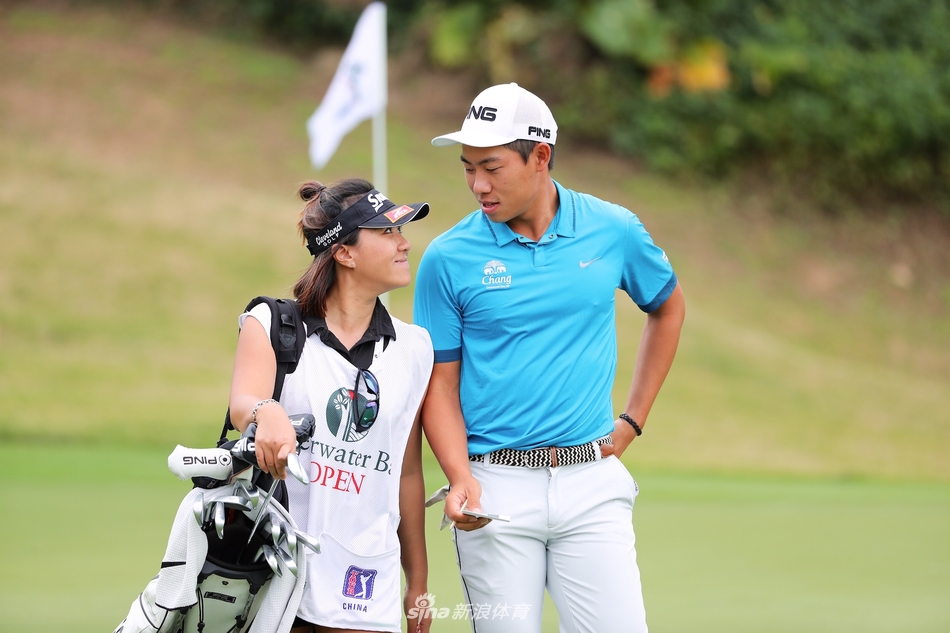 韩裔加拿大球员理查德郑在果岭上仔细研读推杆线路，背景是郁郁葱葱的树林和晴朗天空