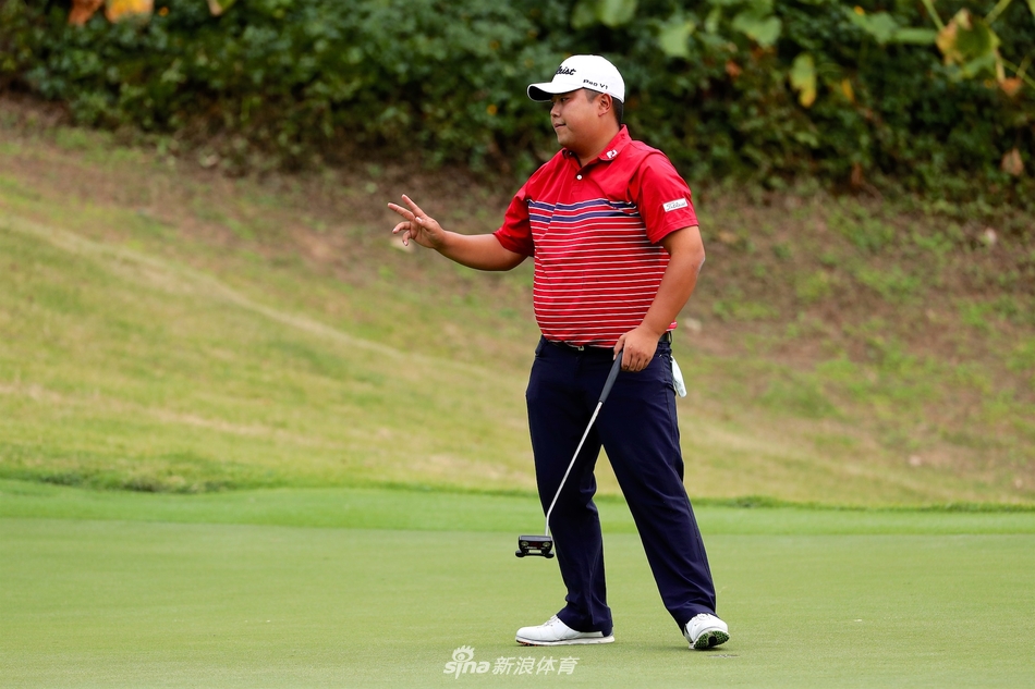 比赛现场观众聚集在果岭周围，屏息凝神观看球员推杆，赛场气氛紧张而专注