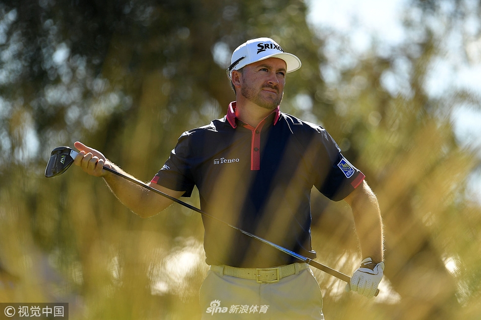 北爱尔兰名将格雷姆·麦克道尔在果岭边复杂的长草中观察球位，思索着下一杆的救球策略，神情严肃。