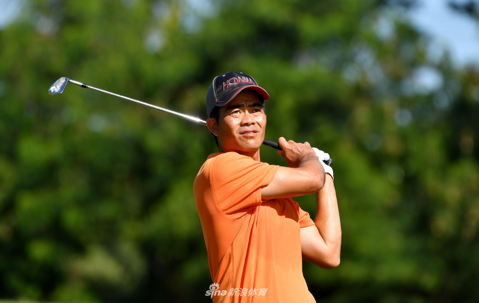 梁文冲在练习场全神贯注地挥杆，白色小球在空中划出一道优美的弧线