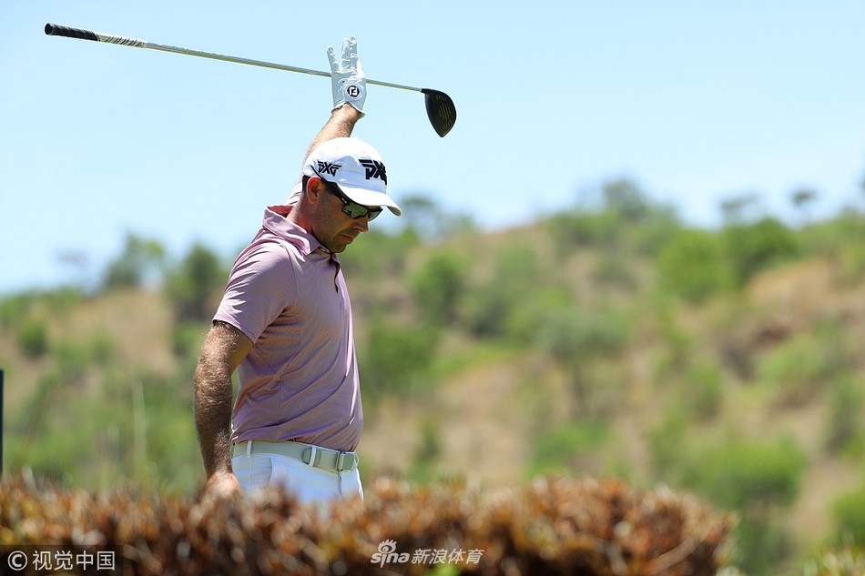 本德·维斯伯格在沙坑中屈膝俯身，全神贯注地执行救球一击，沙砾即将飞溅而起。