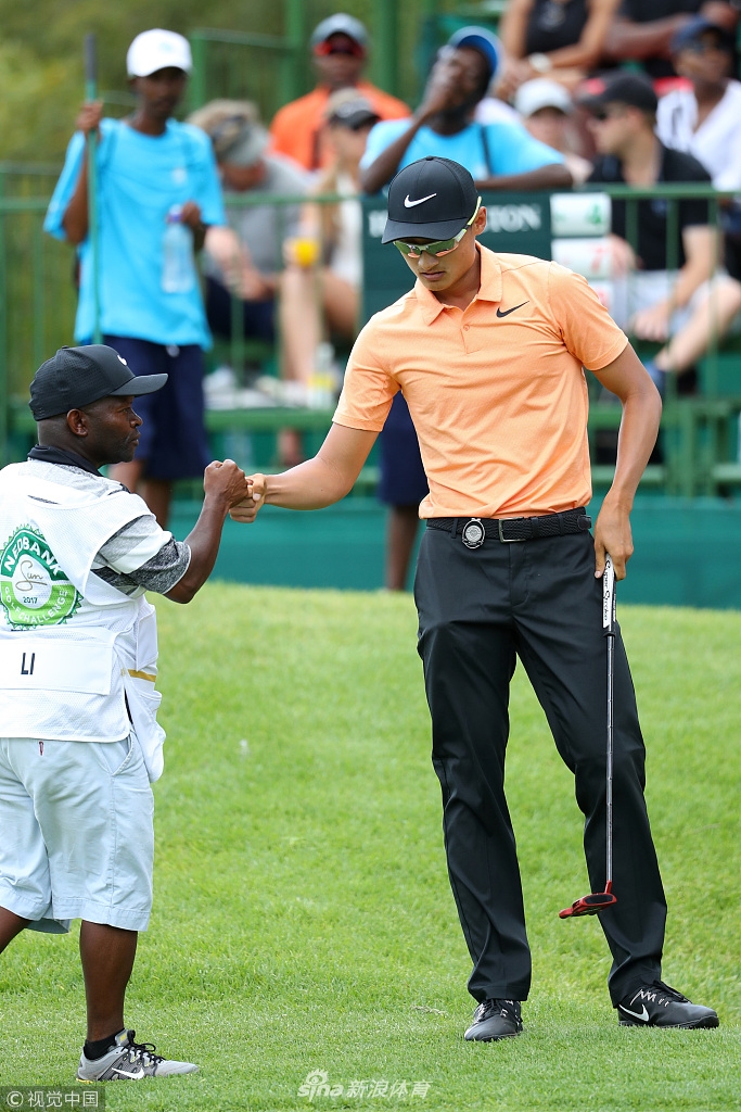 李昊桐与球童在球道上默契击掌，共享比赛中的一次成功配合