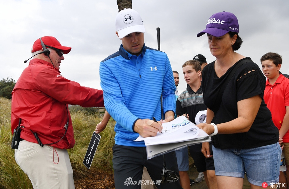 乔丹·斯皮思与业余小球手并肩而立,一同低头分析果岭地形,气氛轻松而专注。
