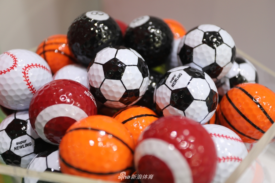 一位观众正兴致勃勃地试用一款红木手柄的推杆，手柄处精致的回形纹雕刻与光滑的杆身形成对比，手感非凡。