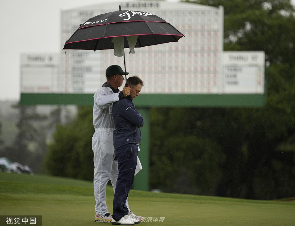 西班牙名将琼·拉姆在奥古斯塔的雨中凝视球道，眼神专注，挑战恶劣天气与领先者宝座。