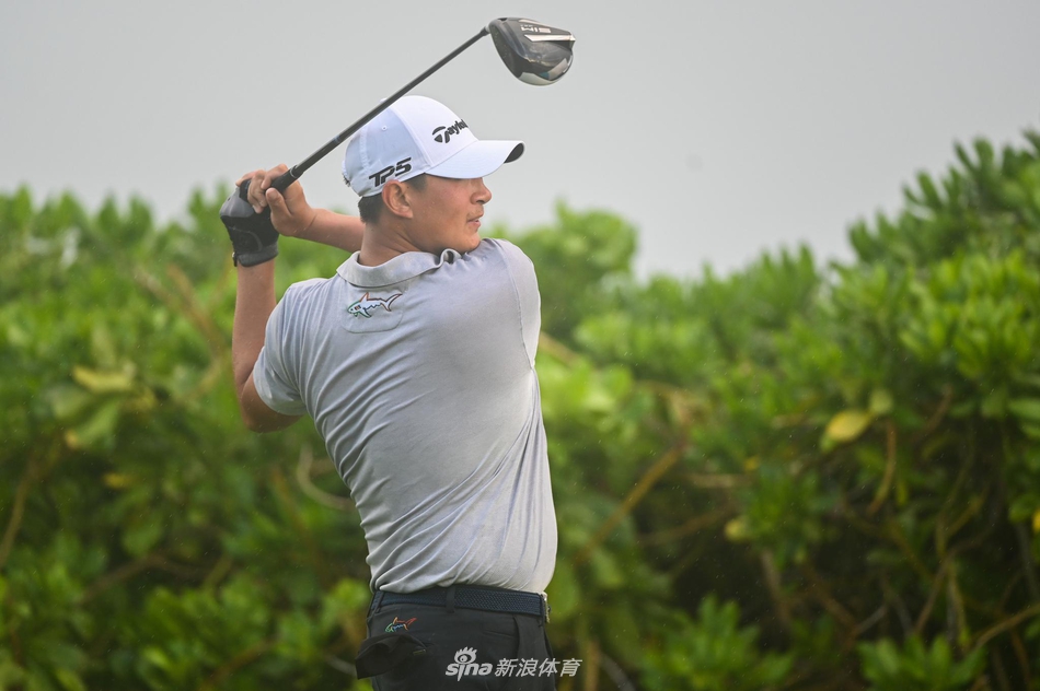 窦泽成聚精会神地观察果岭坡度,为关键推杆做最后准备