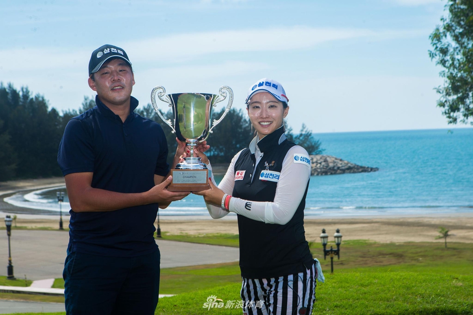 冠军洪兰与球童并肩站立，手持奖杯面向镜头露出胜利者的自信微笑