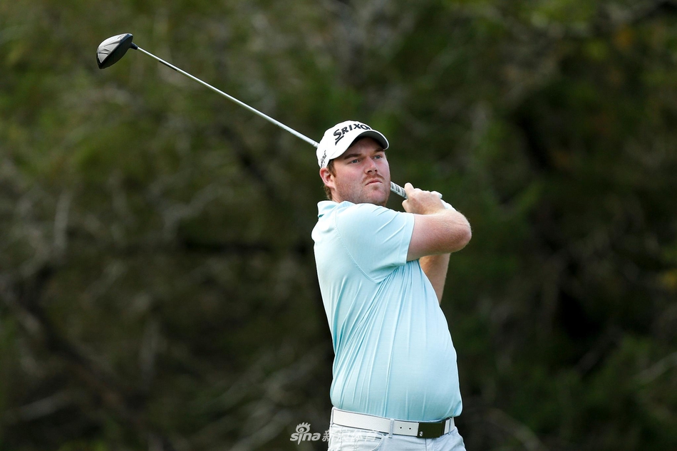 亚当-斯科特在全神贯注地观察果岭地形，为下一杆精巧切击做准备