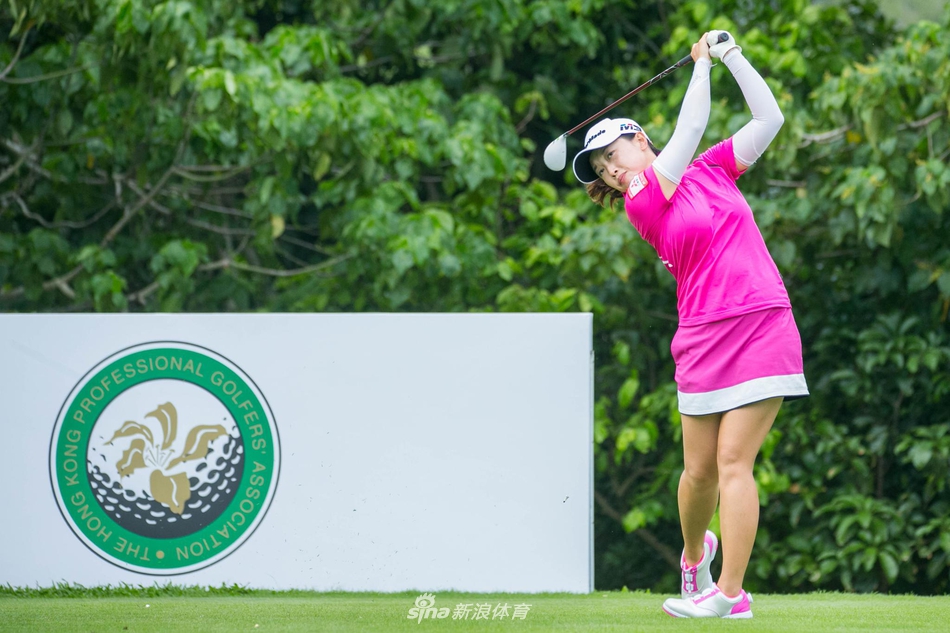 高尔夫球手侧身准备击球,专注神情与自然背景融为一体尽显和谐