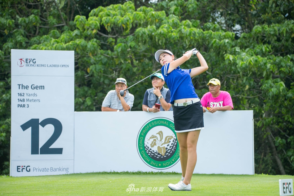 绿茵赛场上女选手优雅挥杆,白色小球划破长空飞向果岭