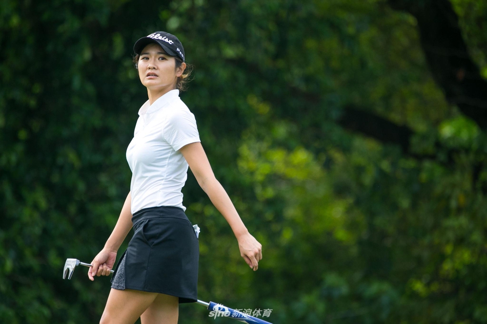 女球员优美完成收杆动作,身影在广阔球场上显得既强大又优雅