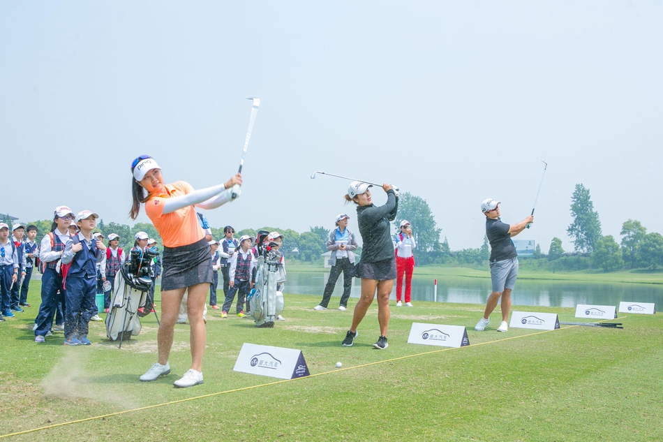 杨嘉欣微笑着为小球迷签名，男孩手捧帽子眼神充满期待与喜悦