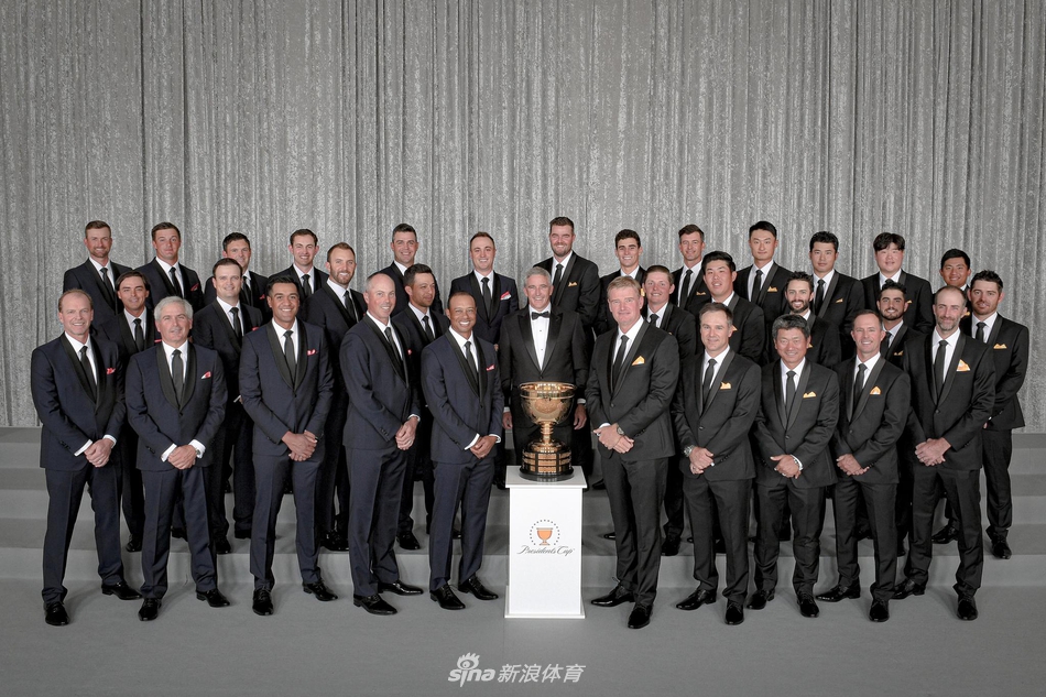 美国队队长老虎伍兹身着经典黑色西装，与国际队队长厄尼埃尔斯并肩而立，两人手握总统杯奖杯模型相视而笑，尽显巅峰对决前的尊重与友谊。