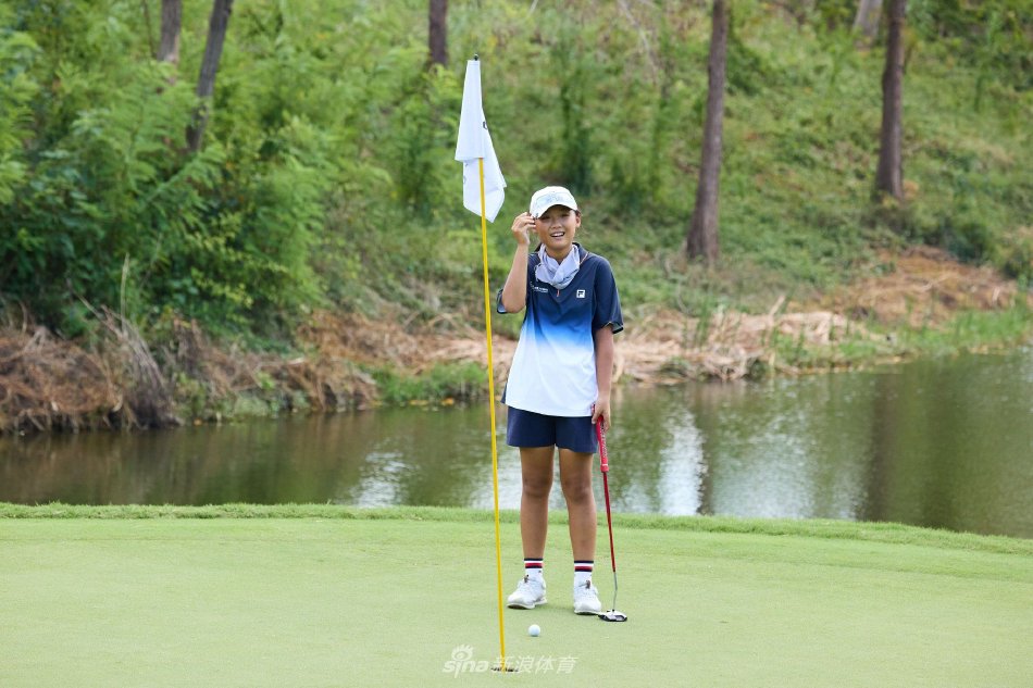 冠军球员高举奖杯瞬间，笑容灿烂，身后是蓝天绿草与共同奋斗的伙伴