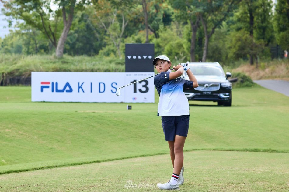 小选手与球童并肩走过葱郁球道，阳光下拉出长长的奋斗身影