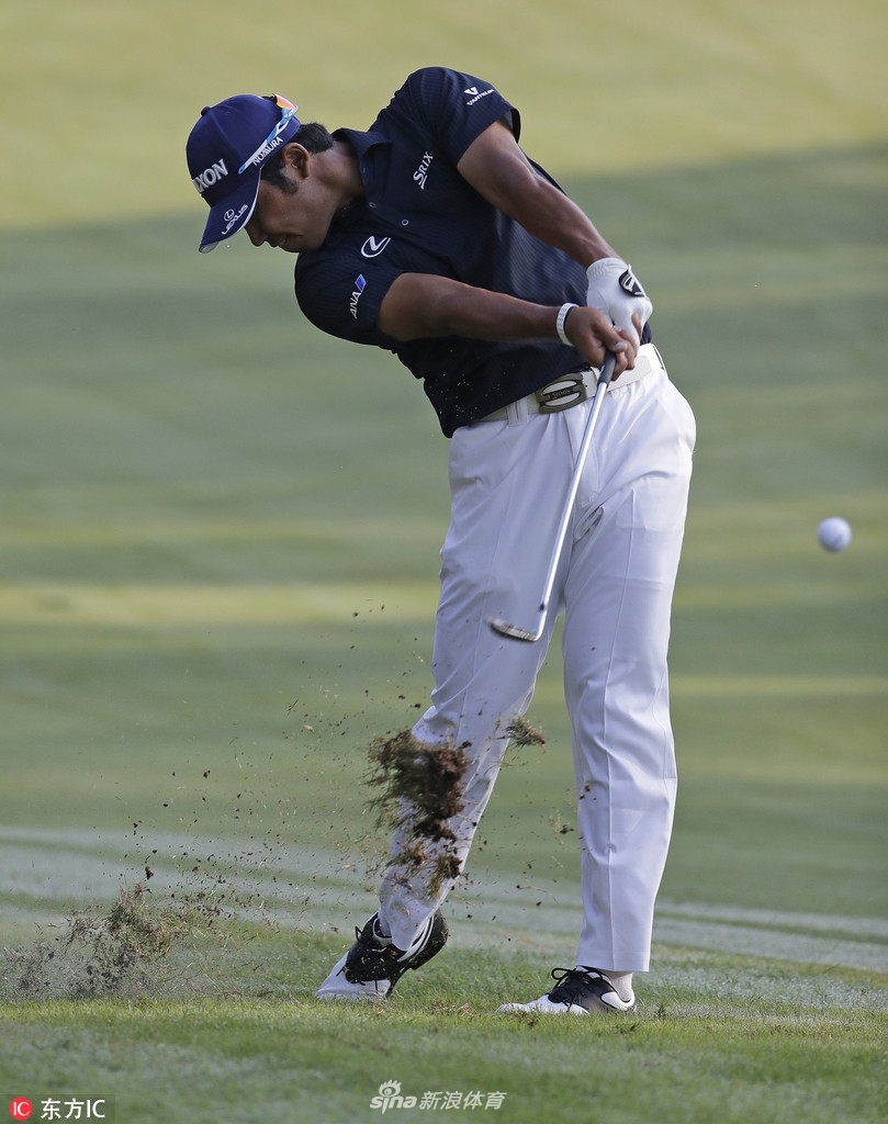 松山英树完成击球后保持完美的收杆平衡，凝神追踪空中小白球的落点