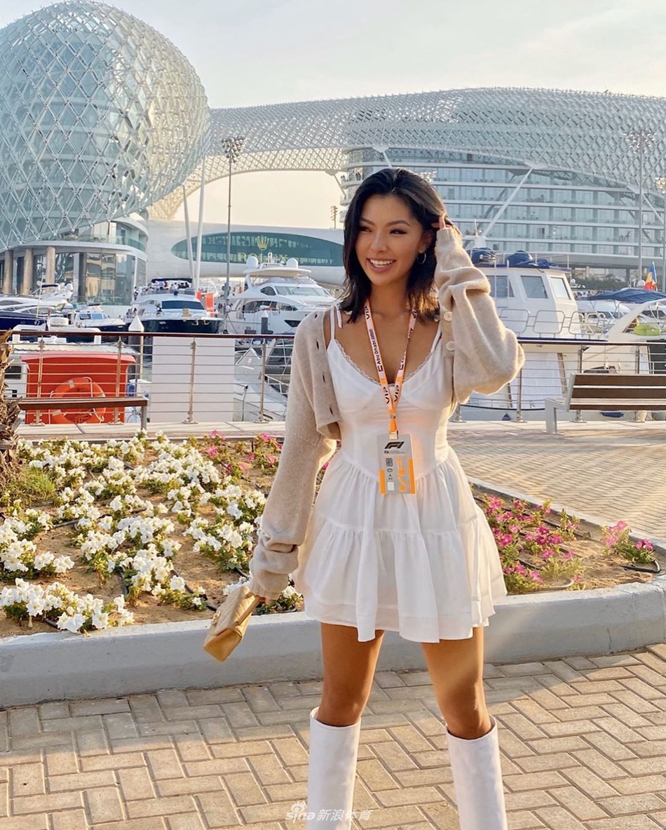 何沐妮在户外阳光下回眸，发丝轻扬，神情惬意，仿佛与自然融为一幅充满生命力的画卷。