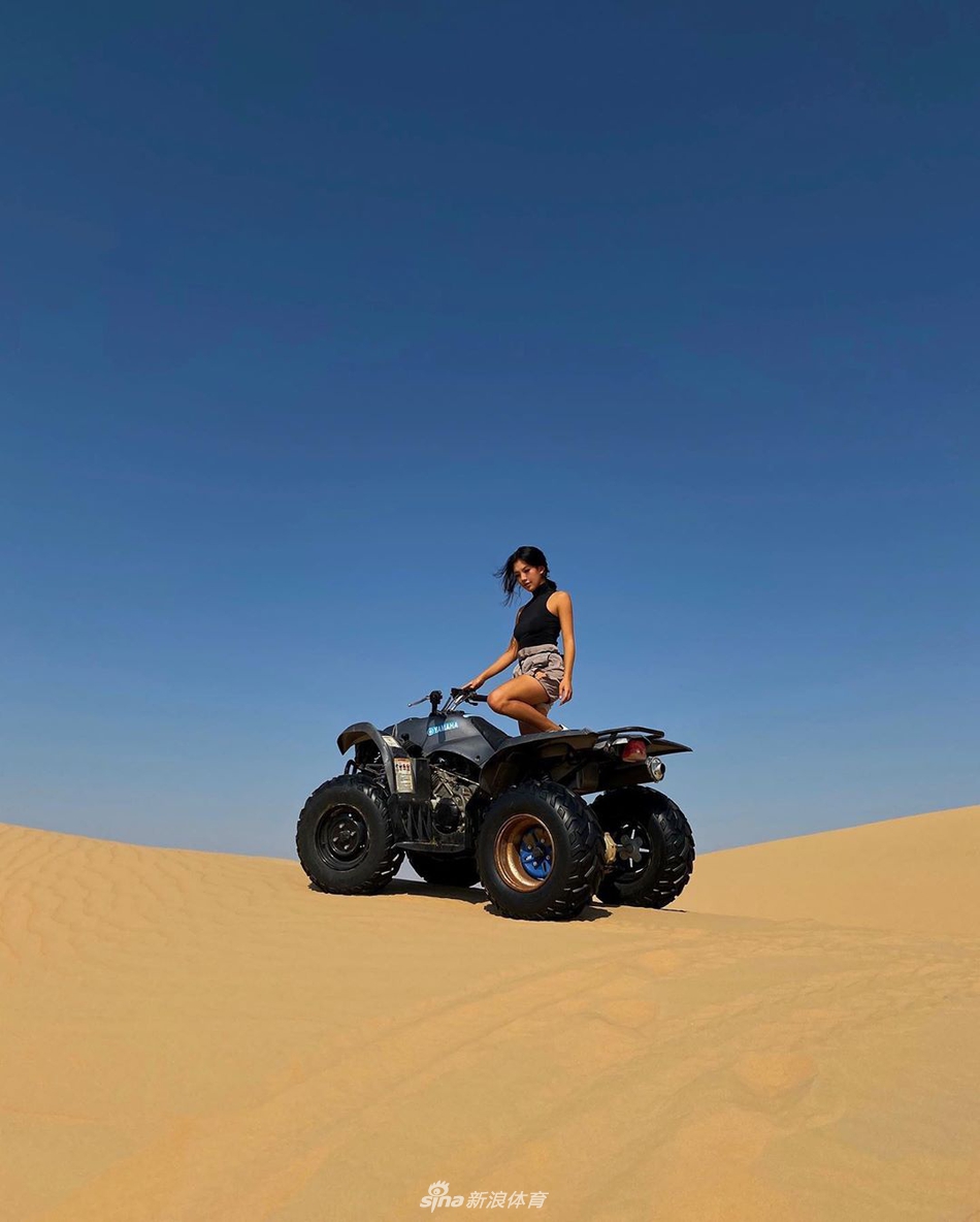 何沐妮一身休闲装扮倚靠站立，姿态放松而自然，散发出自信随性的个性魅力。