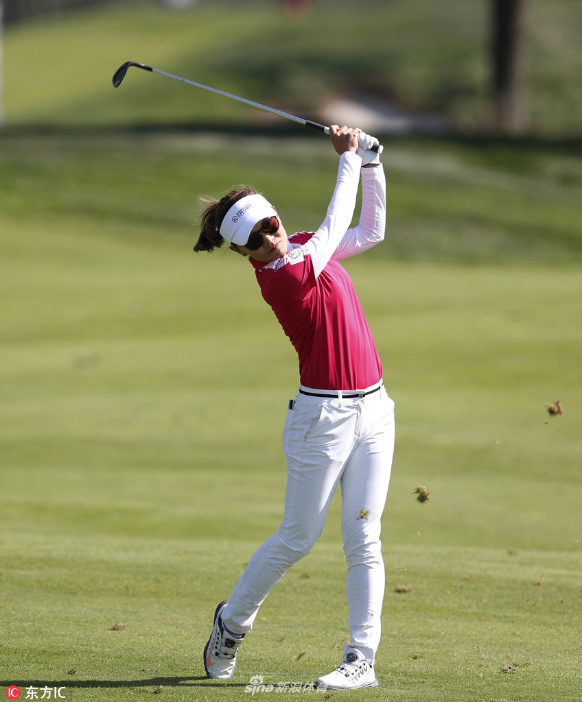 一位高尔夫女将自信挥杆,整套动作流畅而充满力量,阳光勾勒出她完美的发力姿态。