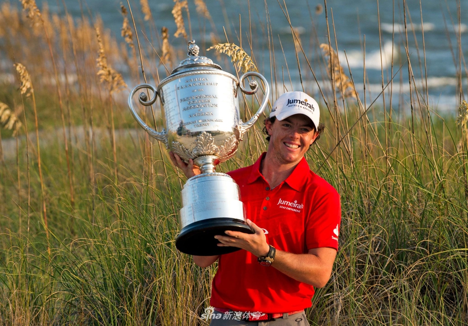 夕阳下的高尔夫球场，伍兹独自拖着球包行走在球道上，身影被拉长，显得孤独而坚定。