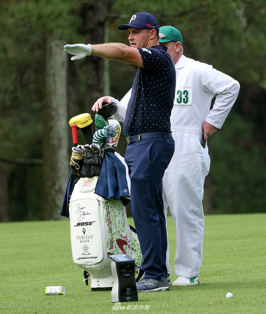 球员俯身细致观察果岭草纹走向，指尖轻触探寻最微妙的坡度